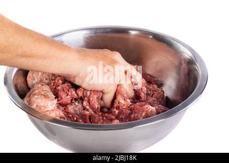 Close-up of a woman's hand kneading ground beef in a bowl - isolated on white background Stock Photo