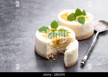 Mini  Cheesecakes decorated with yellow jam on gray background Stock Photo