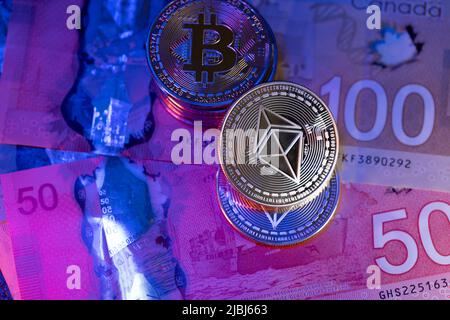 Toronto, Canada - October 30. 2021: Ethereum coin on top of Canadian Dollar banknotes. Trading Crypto currency with CAD Dollar. NFT concept Stock Photo