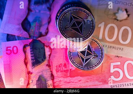 Toronto, Canada - October 30. 2021: Ethereum trading with Canadian Dollar in Canada. Cryptocurrency with Canadian Dollar banknotes Stock Photo