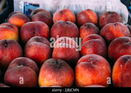 Bright juicy red peaches on a farmer's market stall Stock Photo