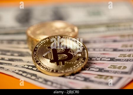 Piled up bitcoin coins on top of US dollar banknotes. Gold BTC coins. Crypto exchange to US dollar concept. Digital crypto currency with paper money Stock Photo