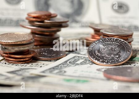 Piled up dollar coins on top of banknotes. Money and cash from USA. Market and trading concept. Half dollar coin reflecting light Stock Photo