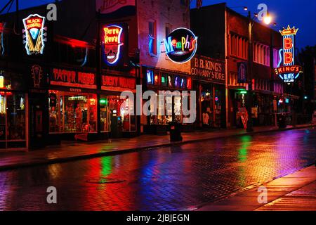 The colorful neon lights of the clubs, taverns and bars on Beale Street in Memphis, Tennessee, are reflected in the rainy street Stock Photo