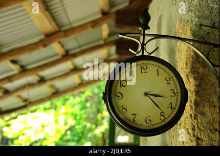 Big old clock on the wall of stone house in nature Stock Photo