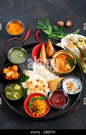 Indian Thali on dark background. Traditional food concept. Organic food concept. Dishes and appetisers of indeed cuisine. Top view, flat view, copy sp Stock Photo