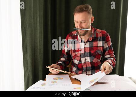 Investor analyzes financial reports and stock market key performance indicators with business intelligence analytics and graphs in home office office. Stock Photo