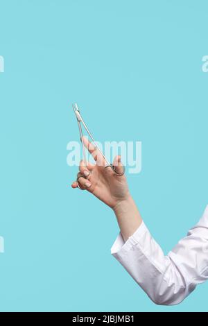 Close up Unrecognizable female surgeon holds needle holder in her hand. Doctor shows how to hold instrument correctly. Stock Photo