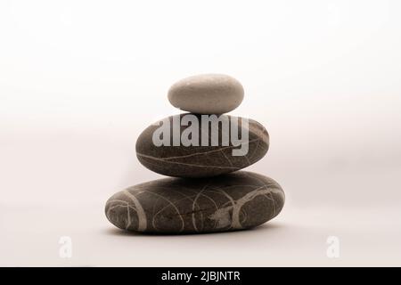 A stack of stones on a white background .Balance and harmony. Copy space.Vertical photo. Spa and healthcare concept. Stock Photo