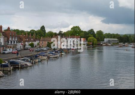 View along the River Thames from Henley Bridge on a dull, cloudy day. Rowers on the water in double scull. Henley on Thames, Oxfordshire, England, UK Stock Photo