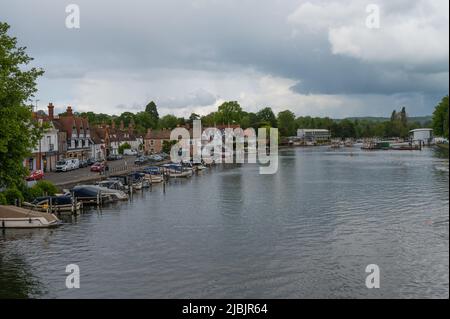 View along the River Thames from Henley Bridge on a dull, cloudy day. Rowers on the water in double scull. Henley on Thames, Oxfordshire, England, UK Stock Photo