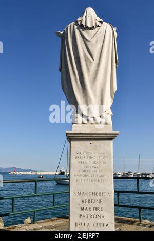 Rear view of the marble statue of Saint Margaret, city patron of Santa Margherita Ligure, on the pier of the old fishing village, Genoa, Liguria Stock Photo