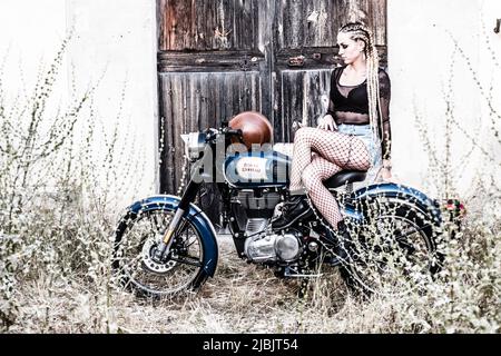 girl and Royal Enfield 500 motorbike, balearic islands Stock Photo