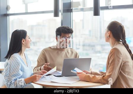 Group of three business people communicating in work meeting at food court cafe Stock Photo