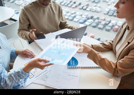 High angle view at group of business people reviewing documents during meeting in cafe Stock Photo