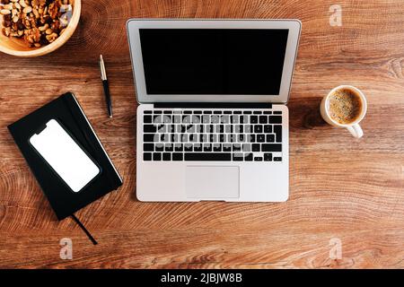 Working at home concept, top view of workspace with laptop computer and smartphone mockup screen on the desk Stock Photo