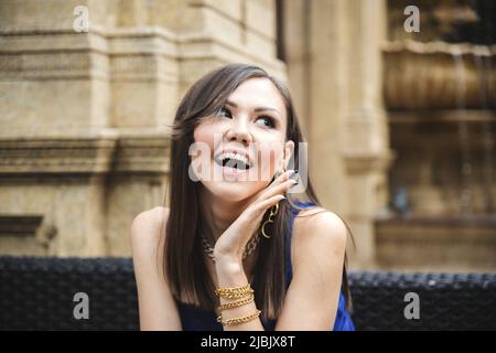 Young woman with surprised emotion on her face on a summer terrace in a restaurant Stock Photo