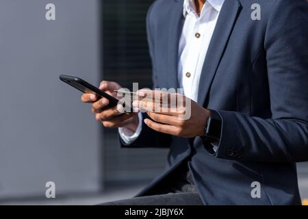 Close-up photo of african american business woman holding phone and credit card, shopping online using ecommerce app Stock Photo
