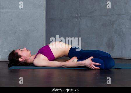 Skinny Girl in Sports Bra Doing Core Stretching Exercise with Back
