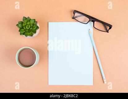 Empty paper with a pen, cup of coffee, eyeglasses and a cactus, brainstorming for new ideas, writing a message, taking a break, home office desk Stock Photo