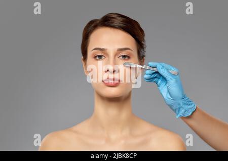 beautiful young woman and hand with scalpel Stock Photo