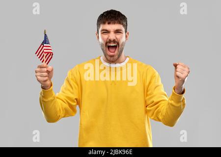 man in yellow sweatshirt with flag of america Stock Photo