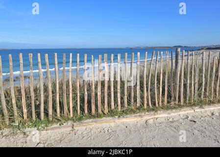 wooden littoral fence in the dune   in front of blue sea and sky in Brittany - France Stock Photo