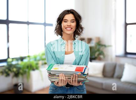 smiling young woman sorting paper waste Stock Photo