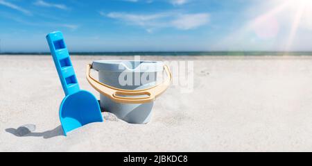 close-up view of toy bucket and spade on sand beach against sea and blue sky Stock Photo