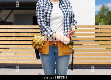 woman or builder with working tools on belt Stock Photo
