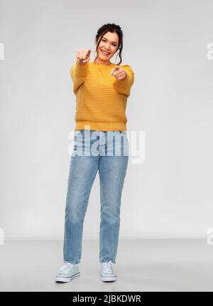 smiling young woman pointing finger to camera Stock Photo