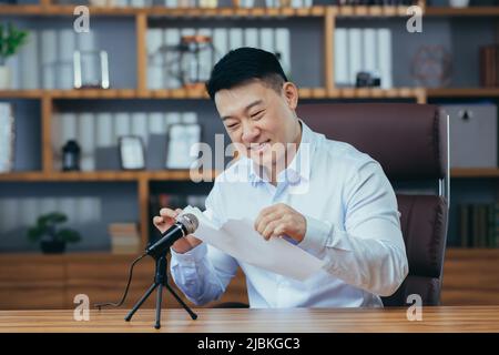 Man tears paper in recording studio, Asian records ASMR sound Stock Photo