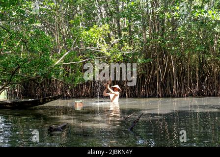 Huong Tra town, Thua Thien - Hue province, Vietnam - April 29, 2022: A man use bamboo fishing traps to catch fish in the lake. Asian man with rural li Stock Photo