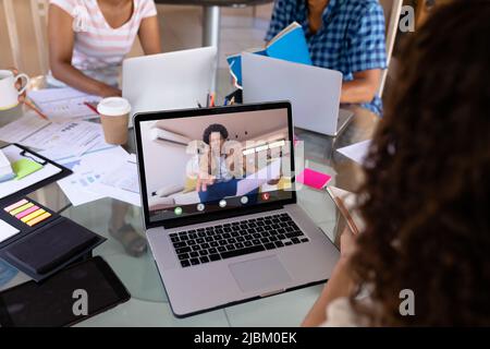 African american angry businessman on video call talking to biracial female colleague in office Stock Photo