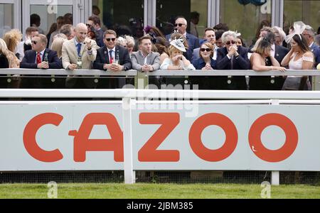 File photo dated 4/6/2022 of racegoers and Cazoo branding on Derby Day during the Cazoo Derby Festival 2022 at Epsom Racecourse, Surrey. Online car seller Cazoo has said it will cut around 750 jobs across the business in the UK and Europe as it looks to make savings of more than £200 million by the end of next year. Issue date: Tuesday June 7, 2022. Stock Photo