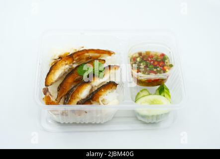 Deep-fried boneless fish over rice with mixed fish sauce, chili, and lime. Take away healthy food in a box from the street food of Thailand. Ready to Stock Photo