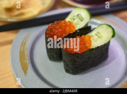 Salmon eggs sushi or Ikura sushi, fresh eggs from salmon fish. Japanese food sushi in small dish on table in restaurant. Stock Photo