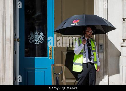 London, UK. 07th June, 2022. A security guard shelter from the sun underneath an umbrella, at the front entrance to the Cabinet Office in Westminster, the morning after Prime Minister Boris Johnson survived a confidence vote. Photo credit: Ben Cawthra/Sipa USA **NO UK SALES** Credit: Sipa USA/Alamy Live News Stock Photo