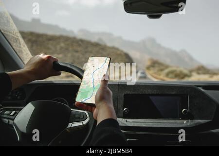Driving a car using the navigation on a smartphone. Mockup with blank white screen. Stock Photo