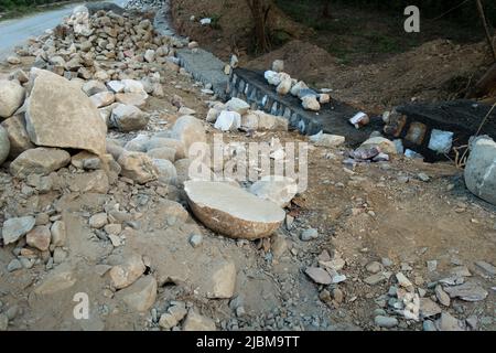 A pile of stone alongside the road for constructing a stone retaining wall to prevent landslide and cutting. Uttarakhand India. Stock Photo