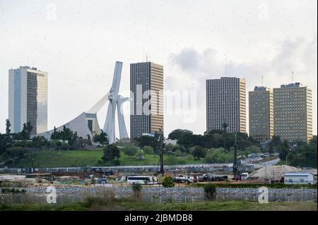 IVORY COAST, Abidjan, city centre Plateau, large buildings and cathedral Saint Paul built 1985 by architect Aldo Spirito, in front chinese working camp of construction company  / ELFENBEINKUESTE, Abidjan, Stadtzentrum Plateau, Hochhäuser und Kathedrale „St. Paul“ gebaut 1985 von Architekt Aldo Spirito Stock Photo