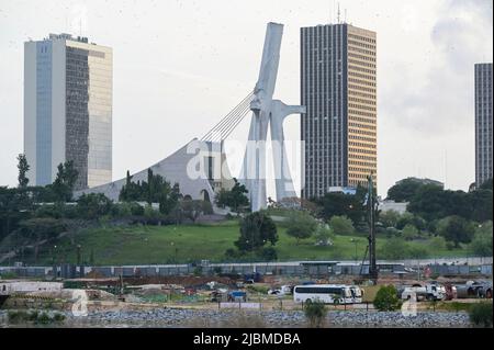 IVORY COAST, Abidjan, city centre Plateau, large buildings and cathedral Saint Paul built 1985 by architect Aldo Spirito, in front chinese working camp of construction company  / ELFENBEINKUESTE, Abidjan, Stadtzentrum Plateau, Hochhäuser und Kathedrale „St. Paul“ gebaut 1985 von Architekt Aldo Spirito Stock Photo