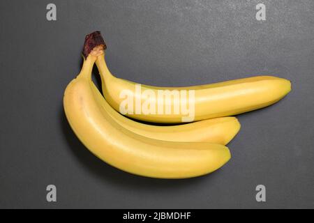 Bunch of ripe yellow bananas on black background. View from above Stock Photo