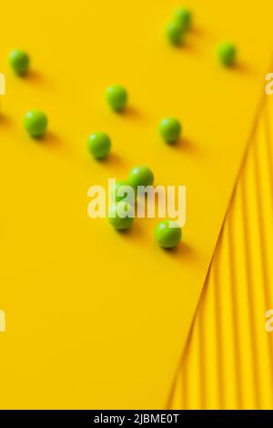 high angle view of small green balls on yellow and blurred background Stock Photo