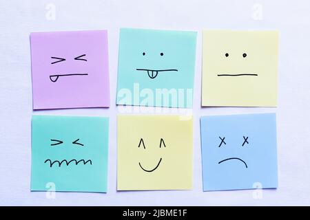 top view of paper cards with various smileys on white background ...