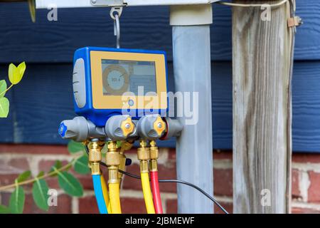 Technician examining air conditioner with multimeter measuring equipment Stock Photo