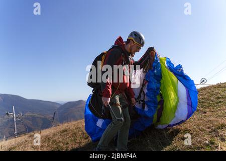 Paragliders preparing for the flight in mountain. Extreme sports activity. Stock Photo