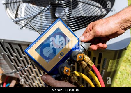 Air repair mechanic fixing using measuring equipment for filling air conditioners Stock Photo