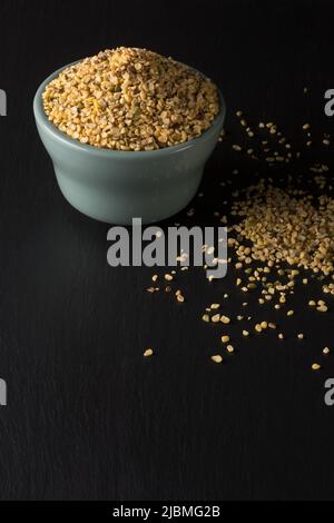 split skin removed mung beans or green grams in ceramic bowl on black surface, also known as moong seeds, staple ingredient in southeast asian dishes