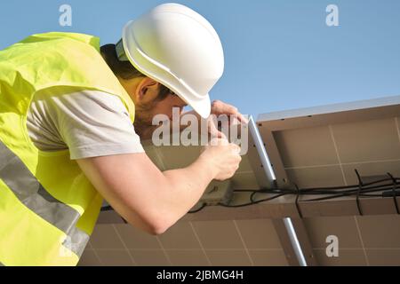 Young technician installing solar photovoltaic panel station. Stock Photo